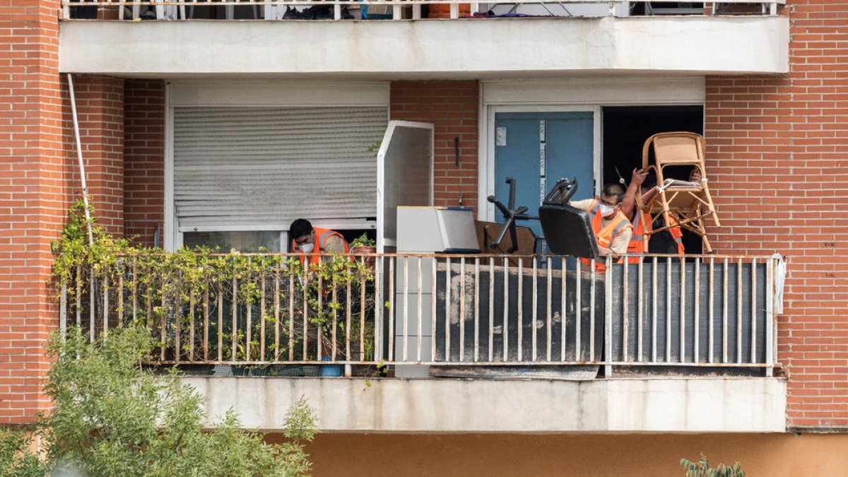 Treballadors treuen al balcó pertinences dels okupes.