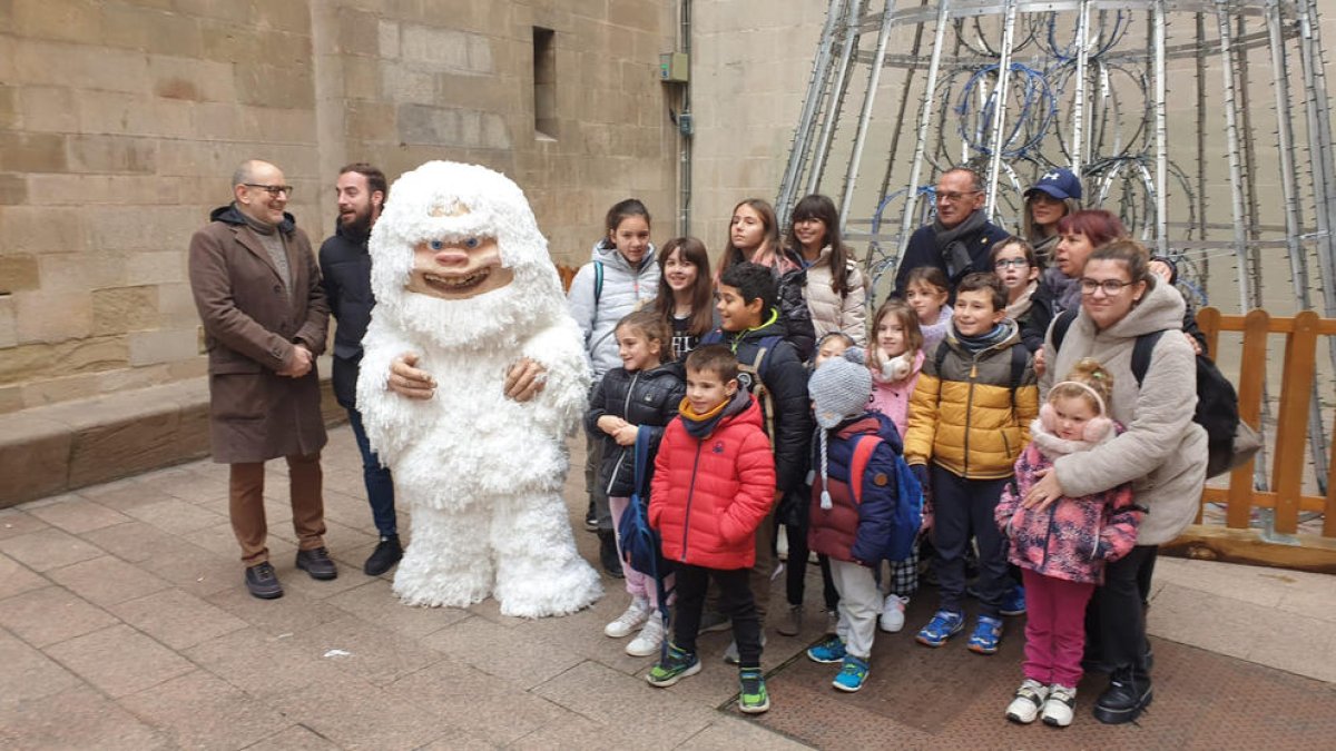 Uno de los Yetis posa junto a un grupo de niños de Benavent del Segrià, el alcalde, Miquel Pueyo, y los concejales de Cultura y Fiestas.