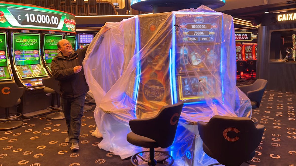 Un treballador del centre 'Unnic', que incorpora el Gran Casino d'Andorra, traient les proteccions de plàstic d'algunes màquines.