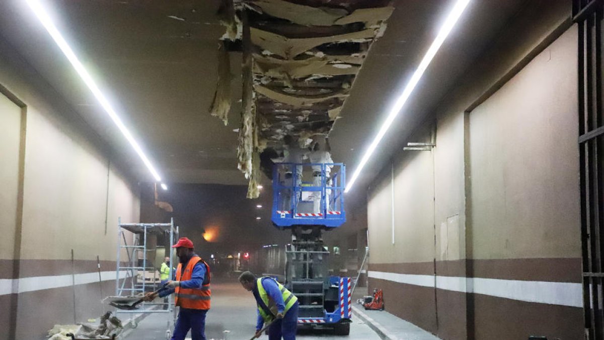 Operaris treballant ahir a la nit en la reparació del fals sostre de l’entrada.