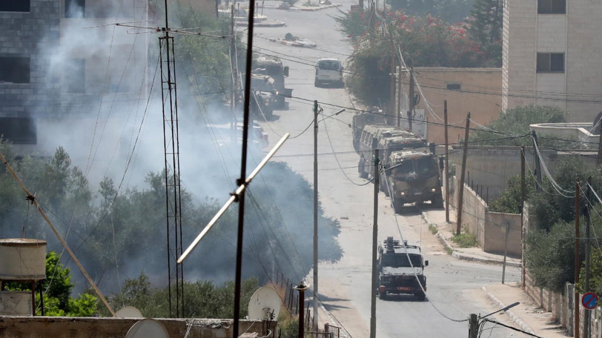 Vehículos militares israelíes se internan en las calles de la ciudad cisjordana de Yenín.