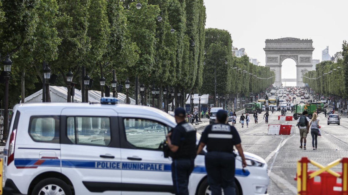 Cotxes de la Gendarmeria francesa al costat de barricades a prop de l’Arc de Triomf de París.