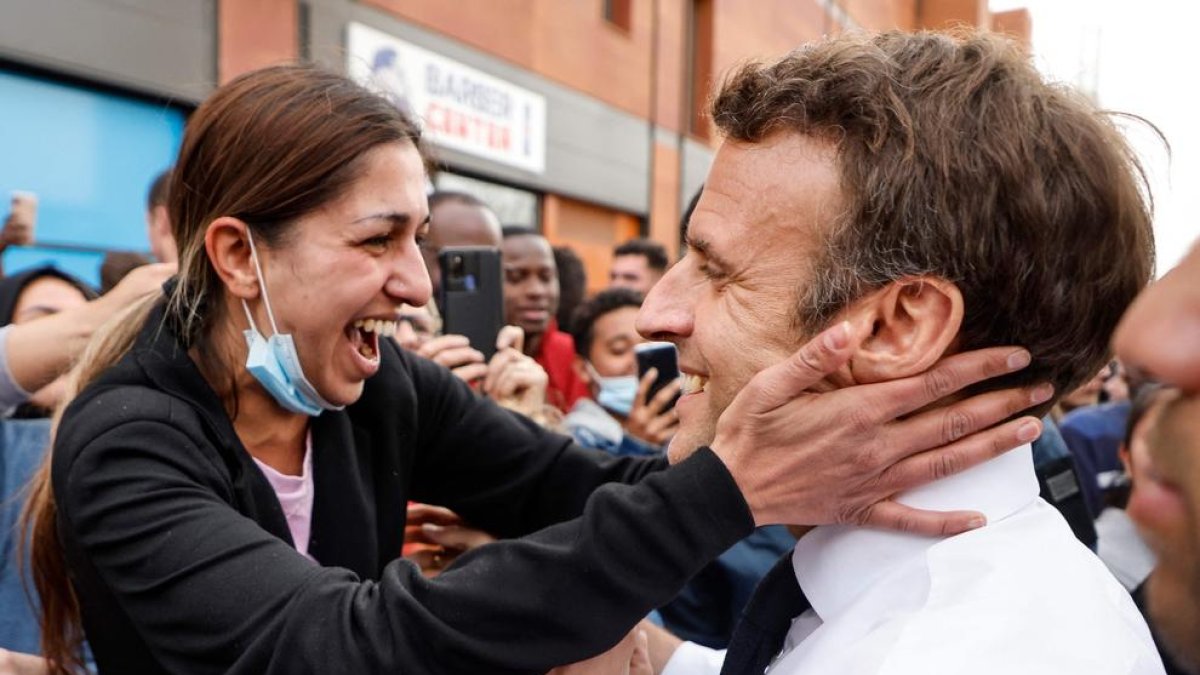 Una dona abraça Macron durant la seua visita ahir a un popular barri de Dijon, a l’est de França.