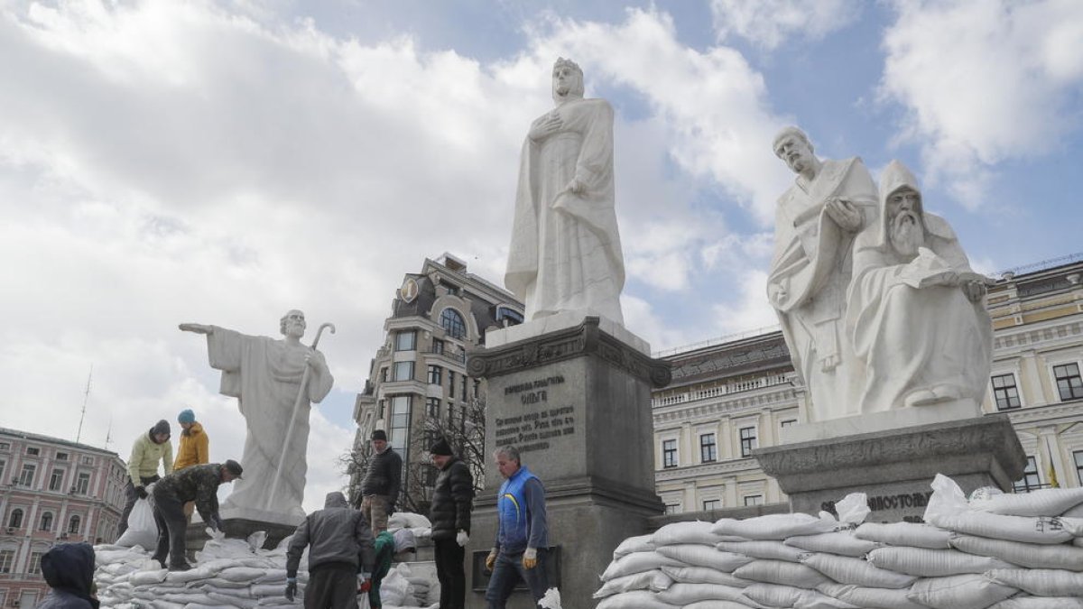 Voluntarios cubren con sacos terreros los monumentos de Kiev para protegerlos de los ataques.