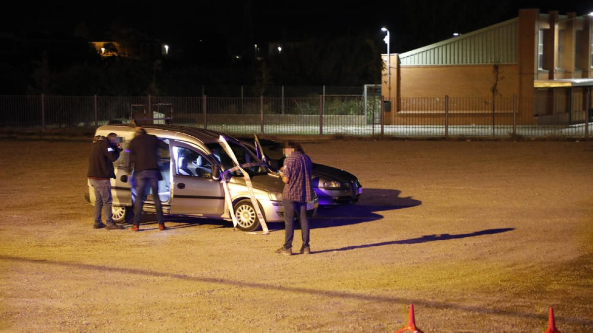 Investigadores inspeccionando una furgoneta en el lugar de crimen el domingo por la noche.