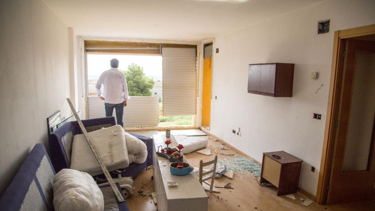 L’alcalde, d’esquena, observa els finestrals arrancats d’un dels pisos saquejats del bloc.