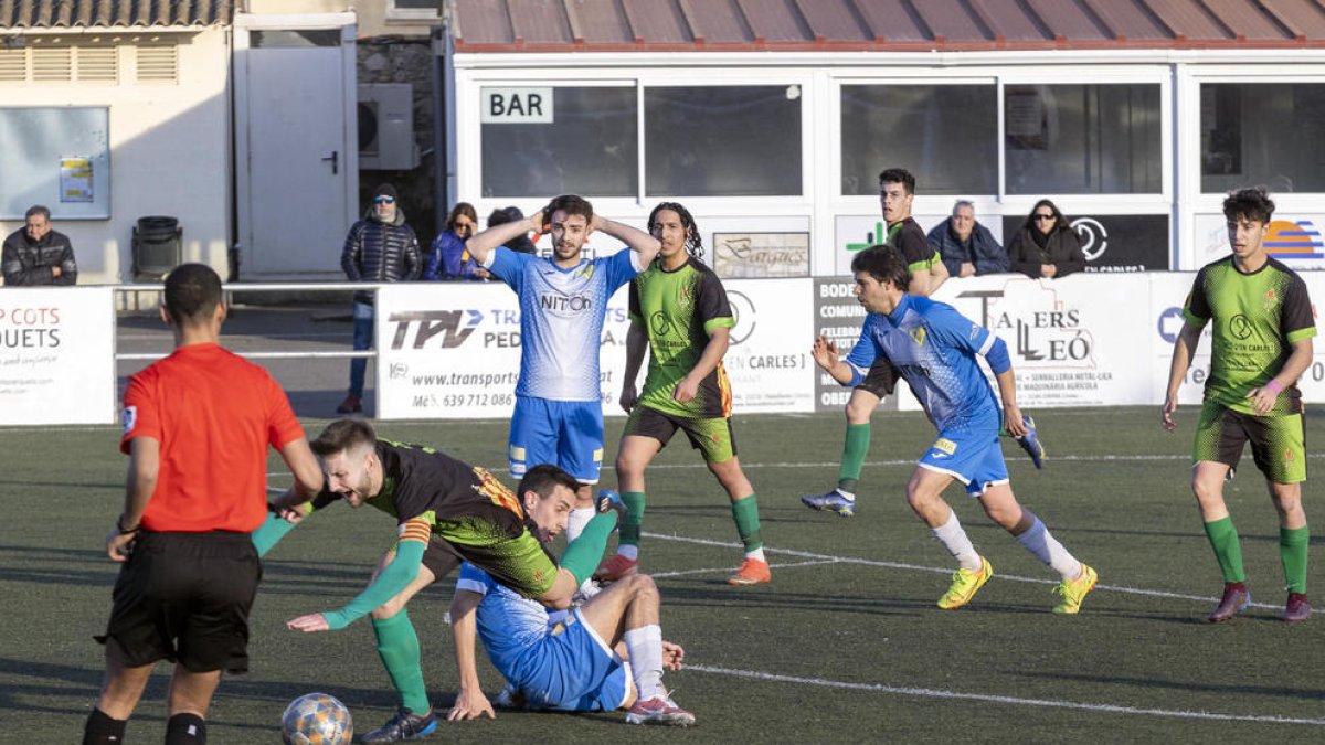 Un jugador de la Seu comet una falta sobre un del Cervera davant la mirada de l’àrbitre.