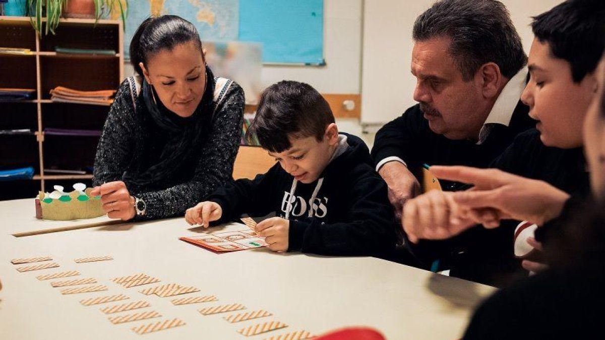 Una família de la comunitat gitana al voltant d’un alumne que fa els deures.