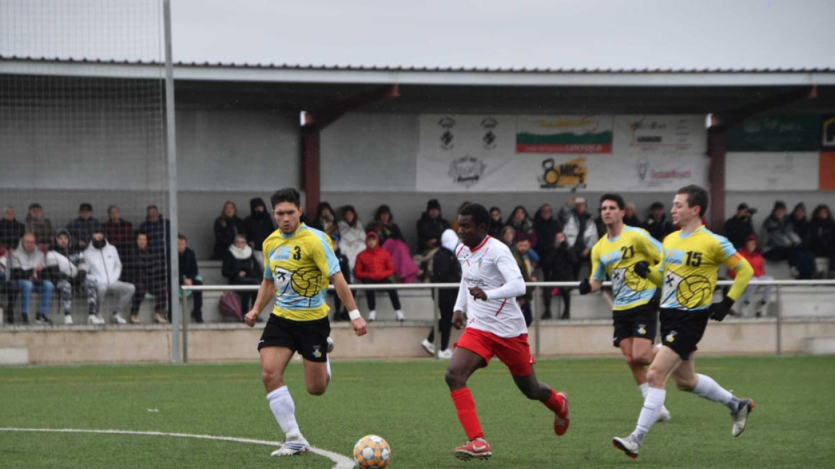 Un jugador del Linyola avança amb la pilota controlada perseguit per diversos defensors del Guissona.