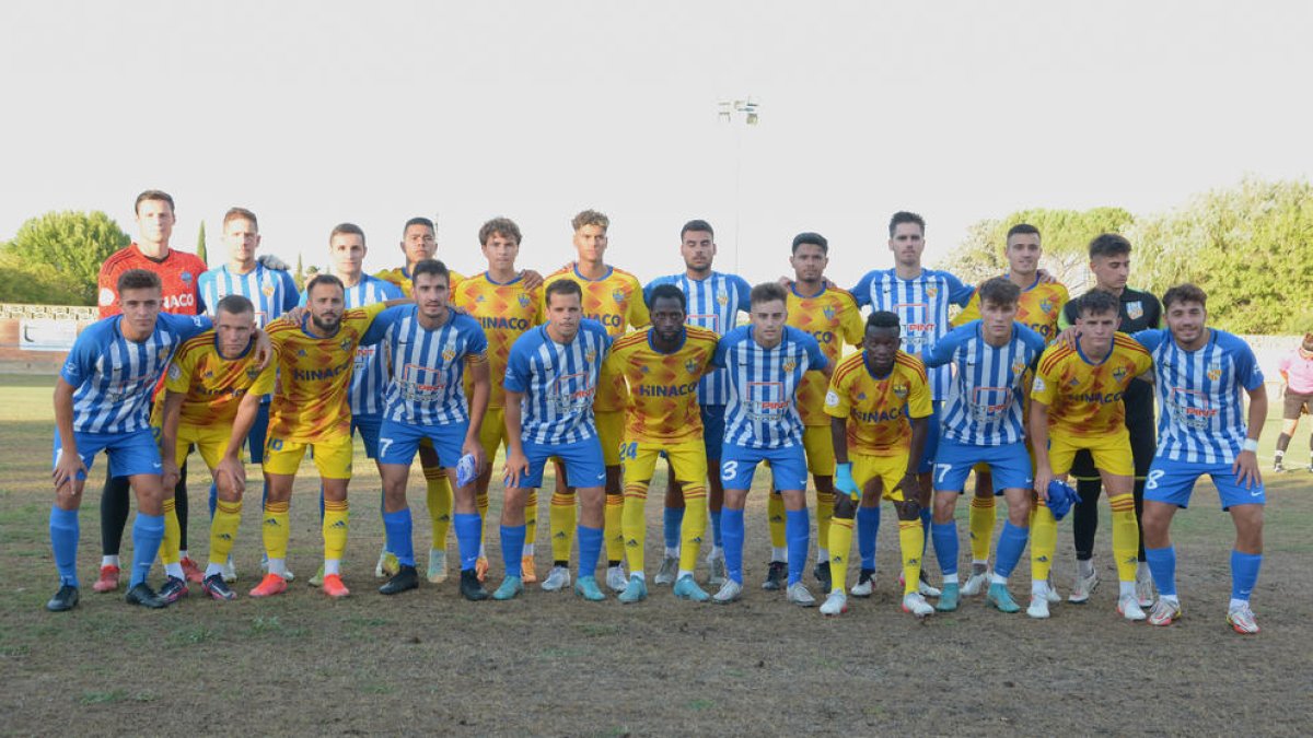Las plantilla del Lleida y del Artesa de Lleida, en una foto conjunta, ayer antes de empezar el partido.