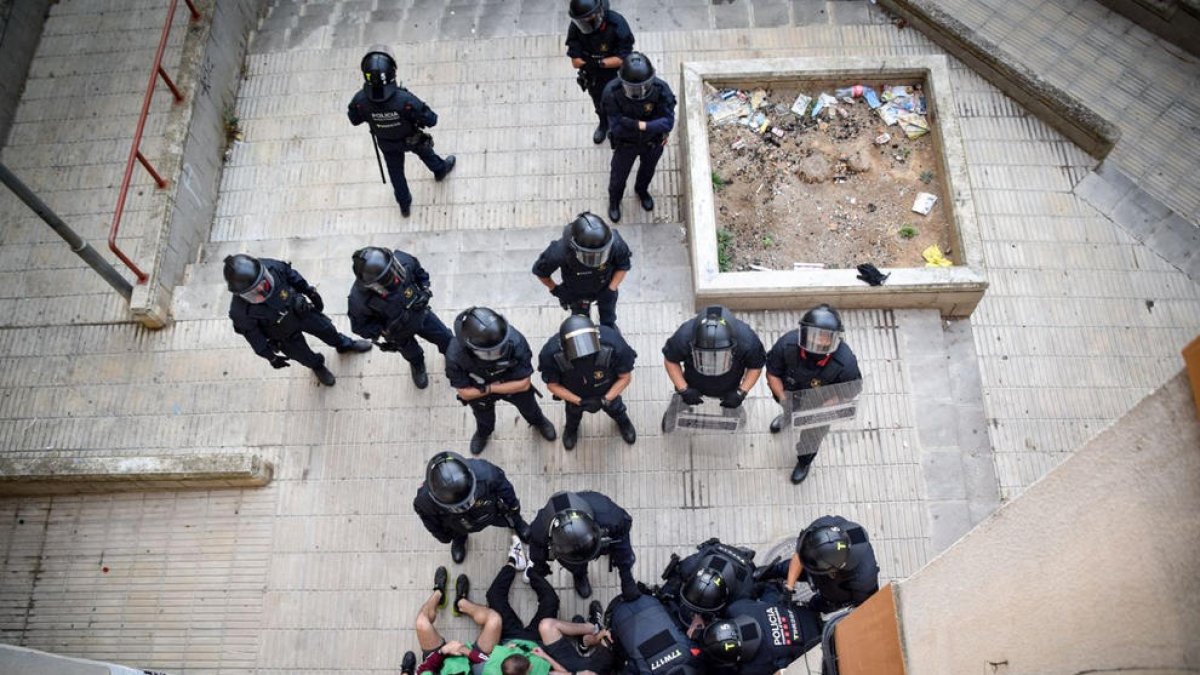 Los Mossos retiran a los activistas de la PAH que bloqueaban la entrada del piso que iban a desalojar.