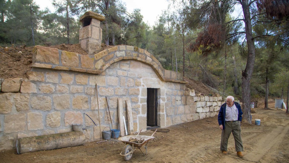 Joan Agustí Tarragó delante de la cabaña que comenzó a construir hace más de cuatro meses y espera inaugurar en primavera.
