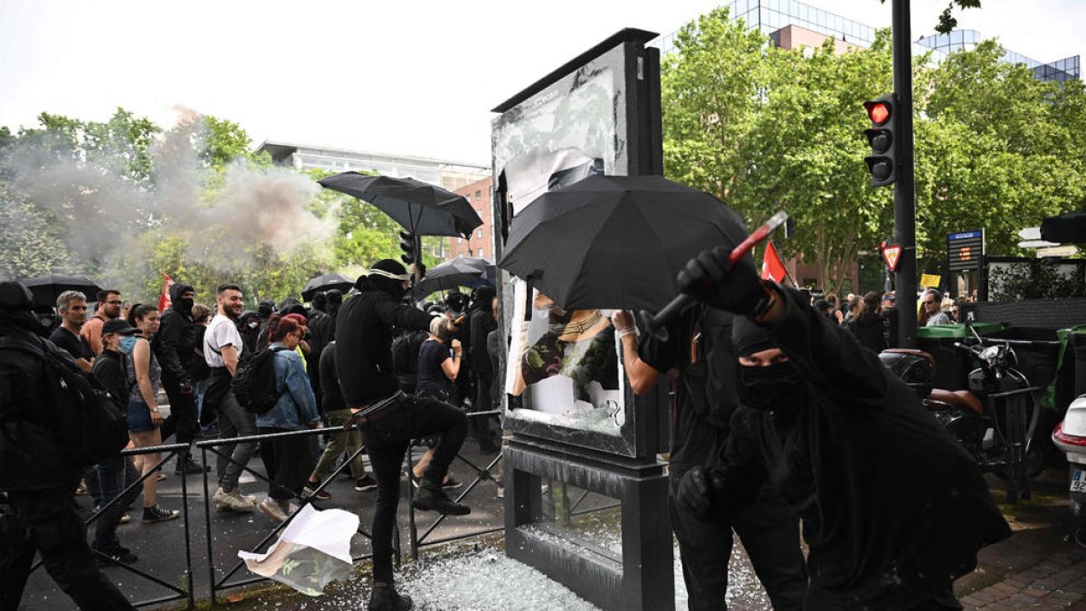 Manifestants trencant mobiliari urbà a Tolosa.