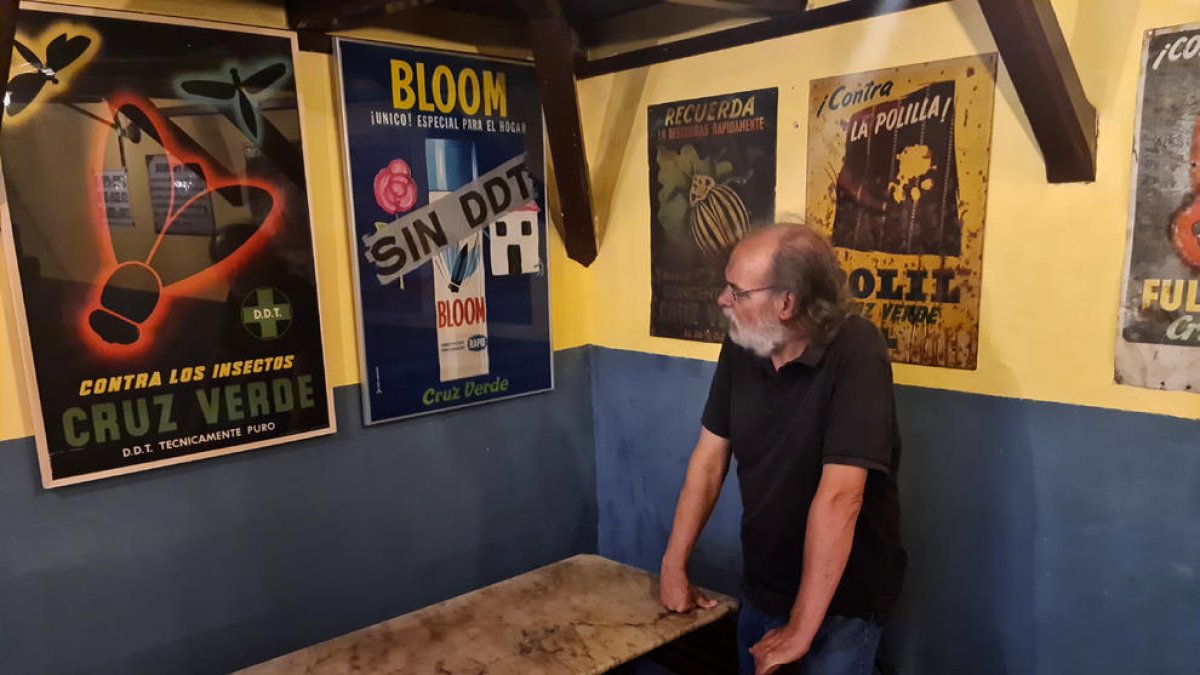 L’historiador Cisco Farràs, al costat de cartells publicitaris de Cruz Verde a les Botigues Museu de Salàs.