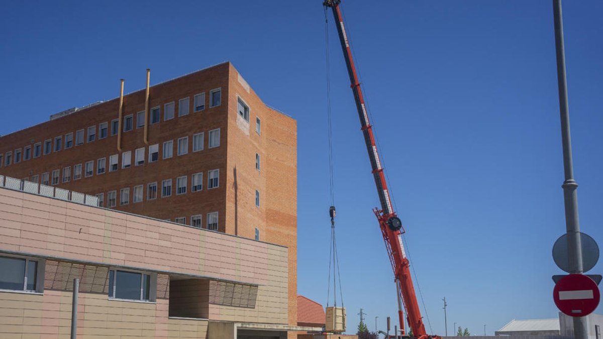 Una gran grúa se encarga de descargar las piezas de los equipos en la planta subterránea.