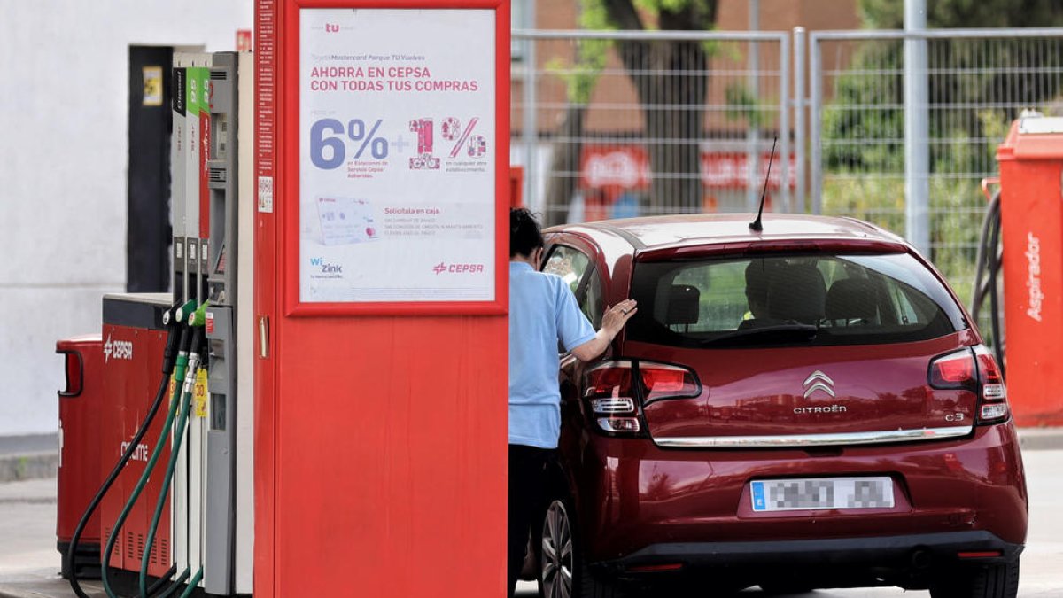 Una dona es proveeix en una gasolinera de Madrid.