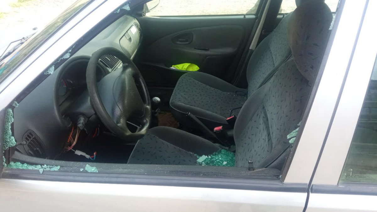 Uno de los vehículos con las lunas rotas.