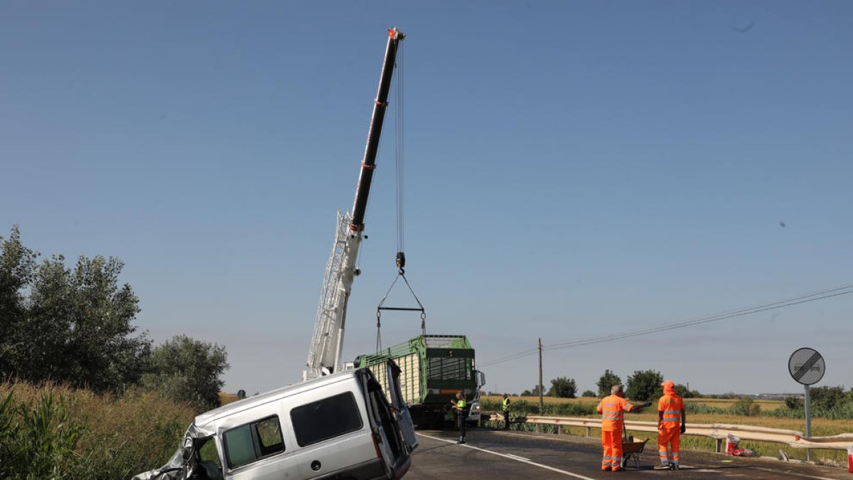 La furgoneta i una gran grua retirant el remolc del tractor
