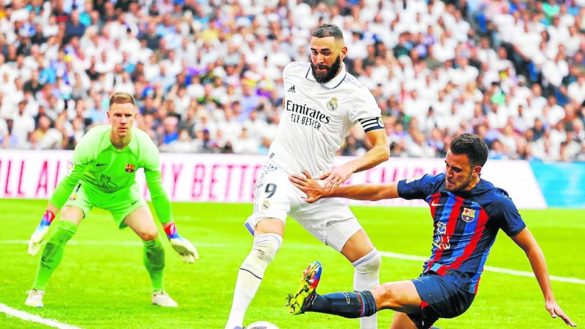 Eric Garcia, que va fallar en el segon gol blanc i va cometre el penal del 3-1, lluita per una pilota davant de Benzema.