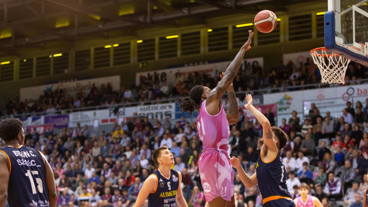Amadou Sidibé, un gegant ahir sota els cèrcols, intenta anotar davant de la defensa del pivot lleidatà de l'Oviedo Marc Martí.