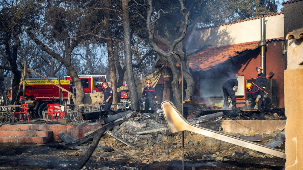 Los bomberos trabajan en un camping afectado por las llamas en Sant Andreu de Sureda.