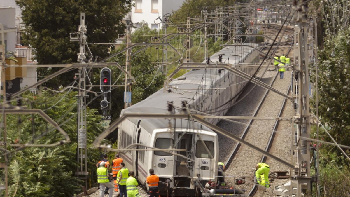 Los equipos técnicos de Renfe y Adif trabajan tras el descarrilamiento de un tren en Sitges.