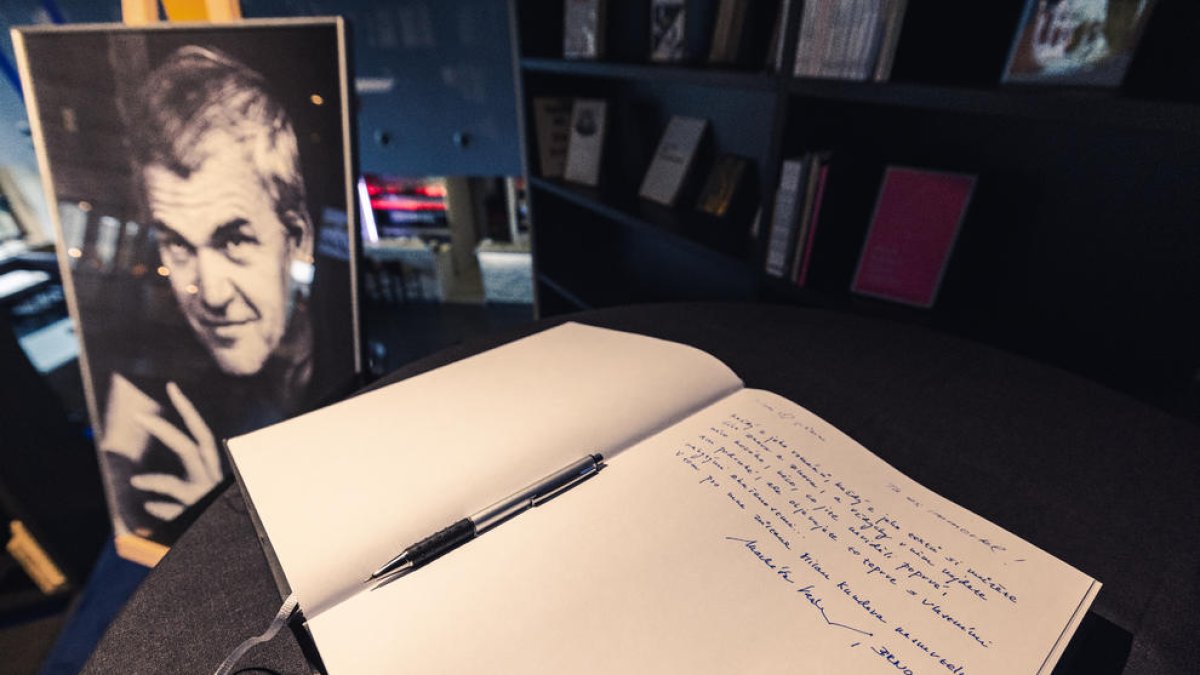 La imatge de l’escriptor txec amb un llibre de condolences davant.
