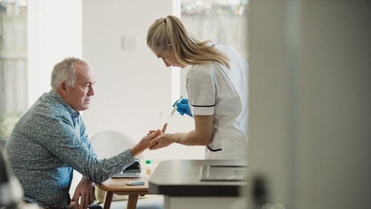 Una infermera pren una mostra de sang a un pacient.