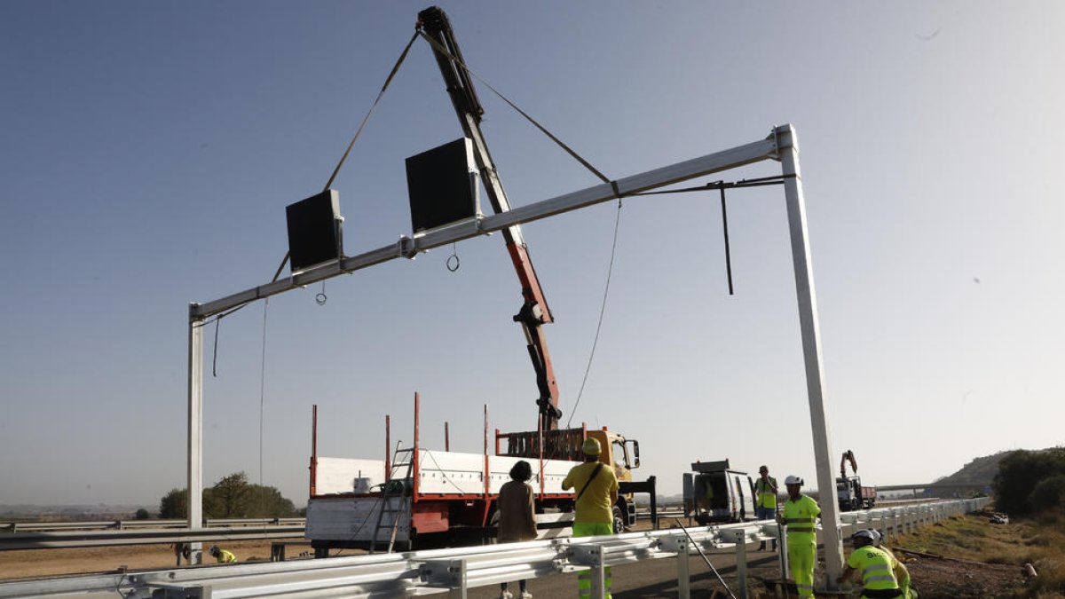 La instal·lació d'un dels pòrtics amb senyals lluminosos a l'AP-2 al seu pas per les Garrigues