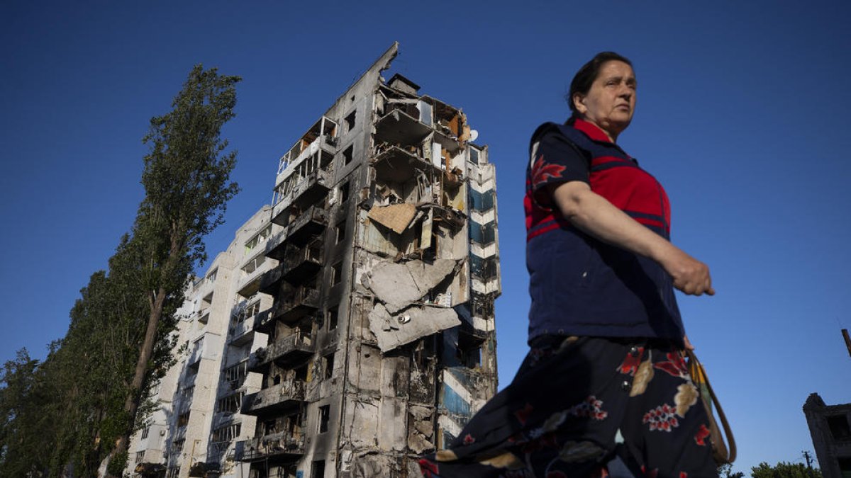 Una mujer camina cerca a un edificio destruido en Borodyanka.