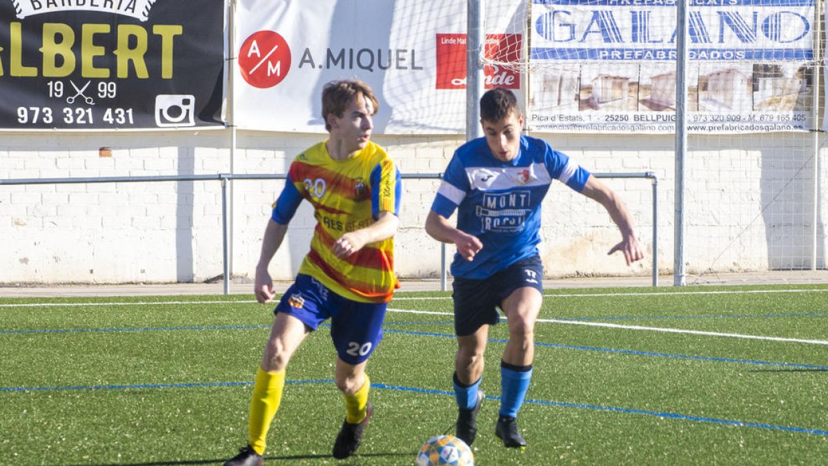 Un jugador del Bellpuig busca el pase ante la presión de un rival.