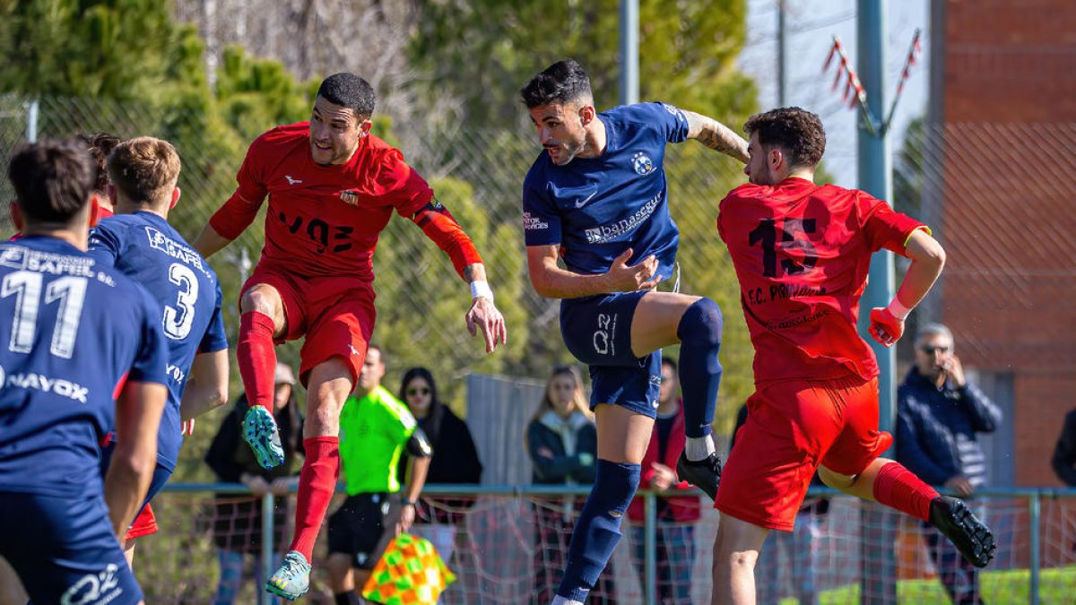 Diversos jugadors dels dos equips disputen una pilota aèria durant el partit d’ahir.