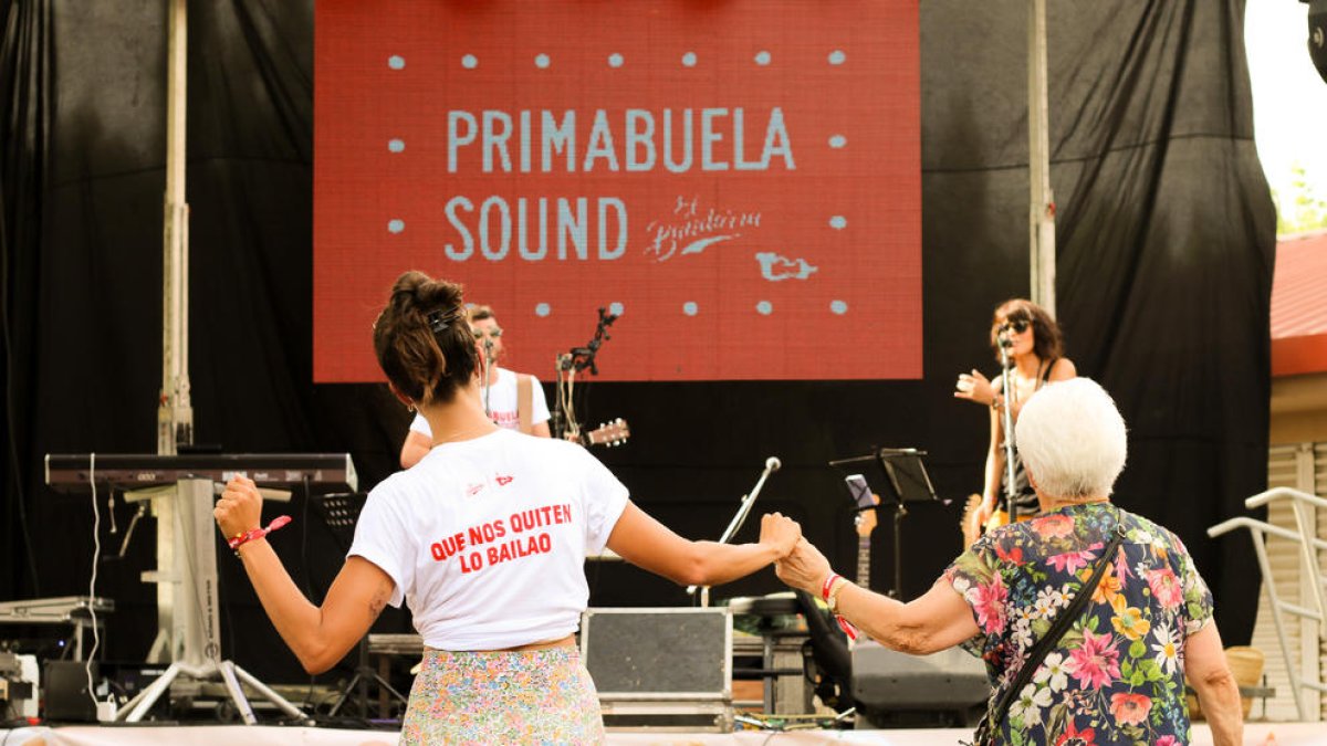 Una de les usuàries balla al costat d’una treballadora del centre durant el concert.