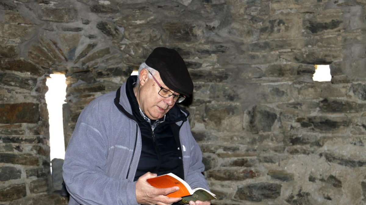 Joan Antoni Baron, unos de los promotores de Vall Ferrera Lllegeix, con un libro dentro de la ermita Sant Quirc d'Alins.