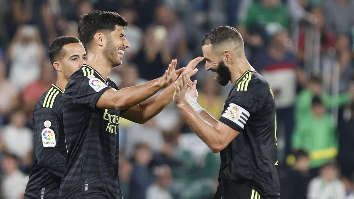 Benzema celebra un gol con Marco Asensio.