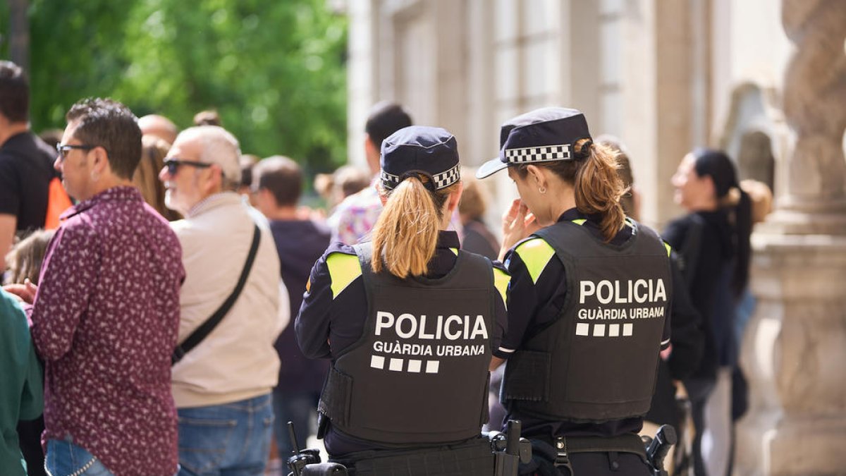 Dos agentes de la Guardia Urbana durante una patrulla por el Eix Comercial durante la Festa Major.