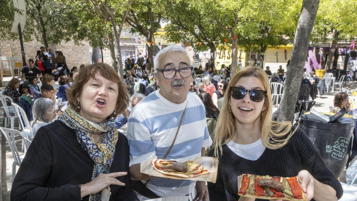 Tres vecinos degustando ‘cócs’ ayer a mediodía.
