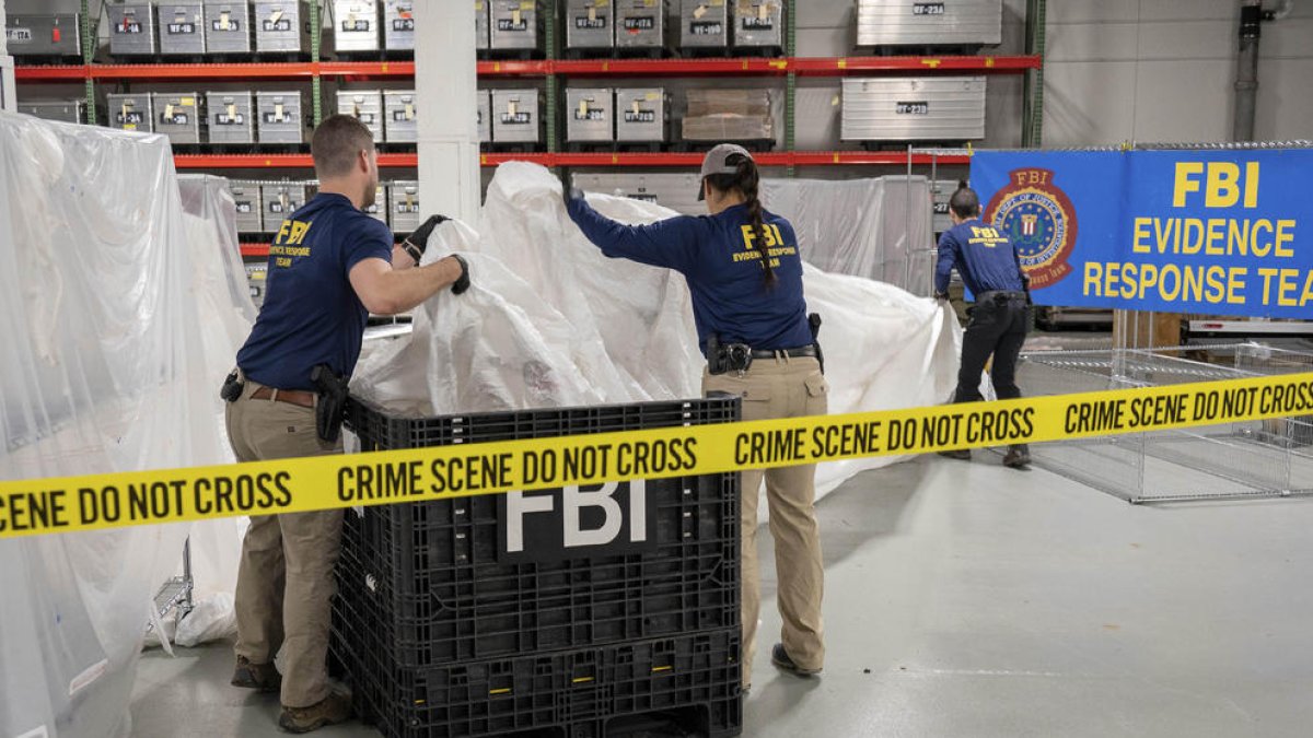 Agentes del FBI manipulan los restos del globo chino derribado.