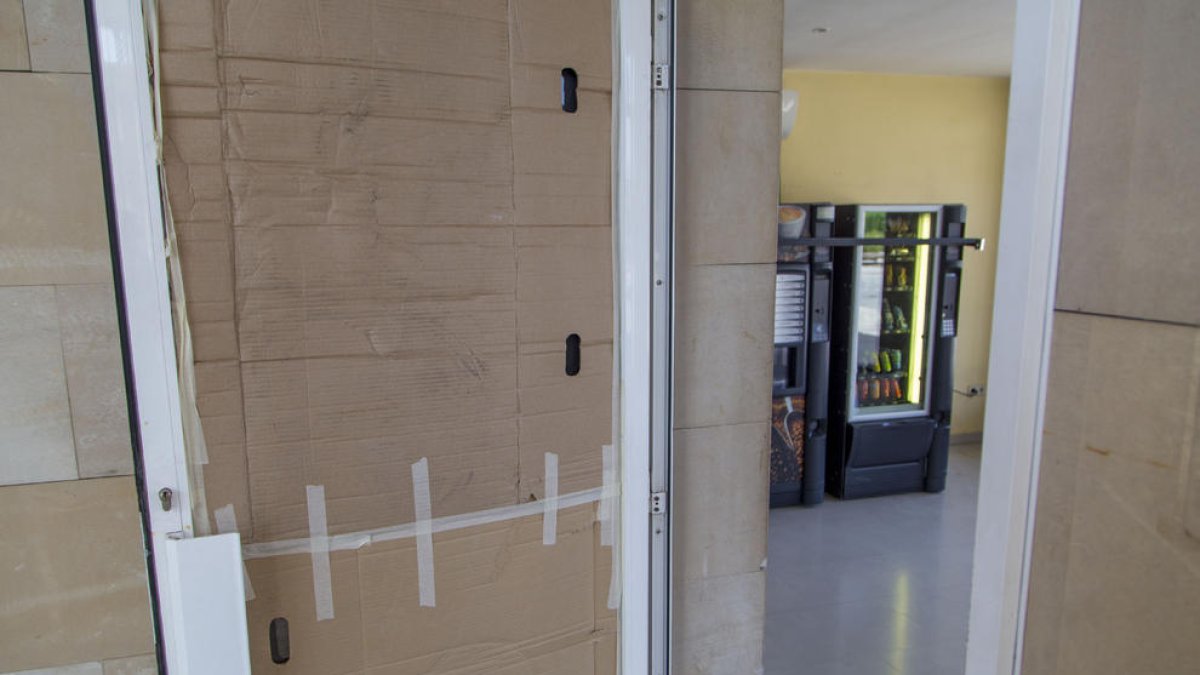 La porta amb el vidre fracturat a la sala del cementiri.