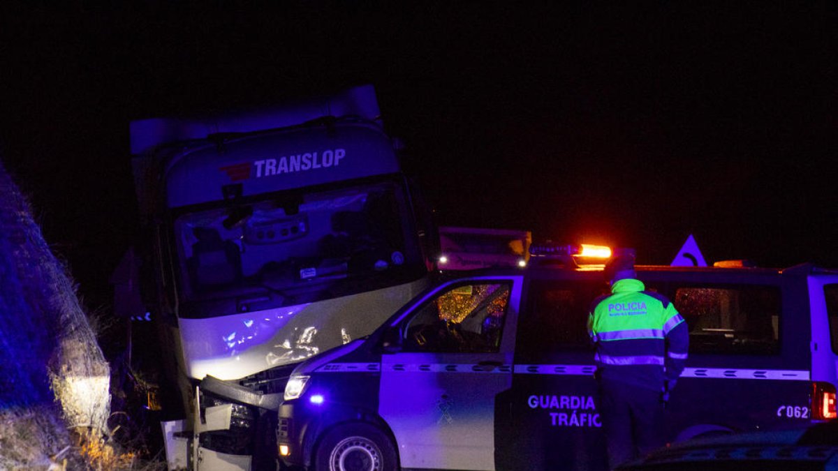 El camión accidentado, un agente de Mossos y una furgoneta de Atestados de la Guardia Civil.