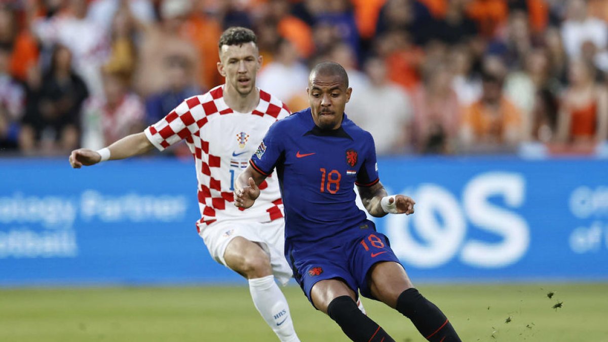 Donyell Malen intenta controlar el balón ante el croata Ivan Perisic.