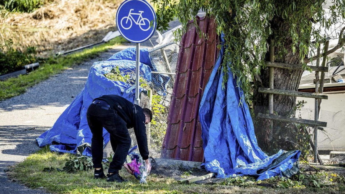 Una persona diposita un ram de flors a l’escena de l’accident.