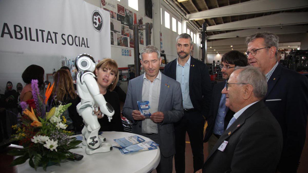 Cambray y otras autoridades, con Miquel, delante de un robot creado por La Salle de la Seu para mejorar la inclusión del alumnado con TEA.