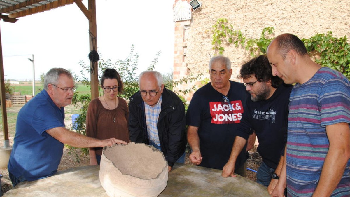 Arqueólogos, autoridades y el propietario de la tinaja, ayer en Vallverd.