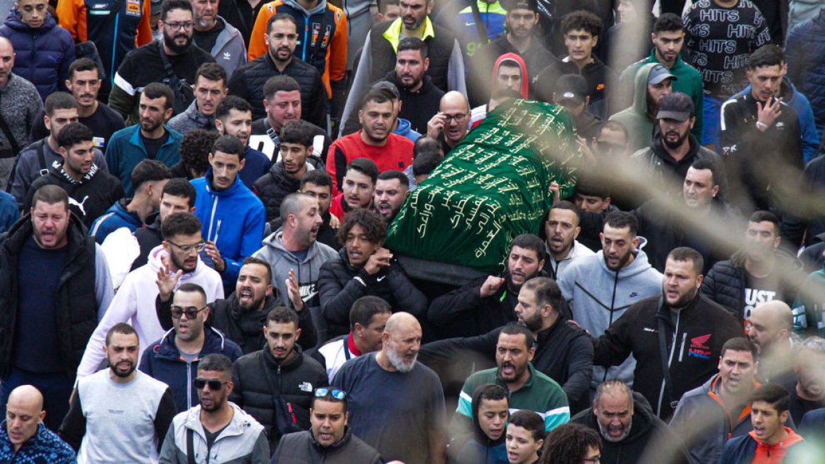 Varios hombres llevan a hombros el ataúd del niño.