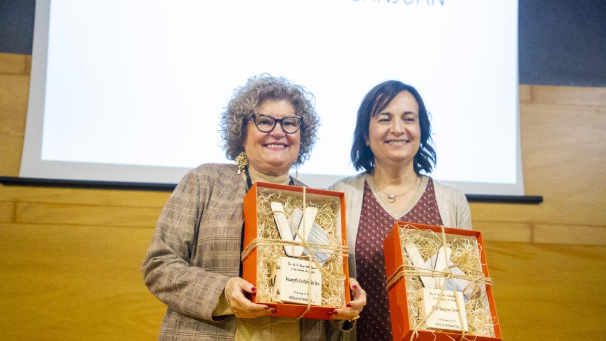 Las homenajeadas, Assumpta Costafreda y Pilar Sanjuan, sosteniendo la figura creada por Ilersis.