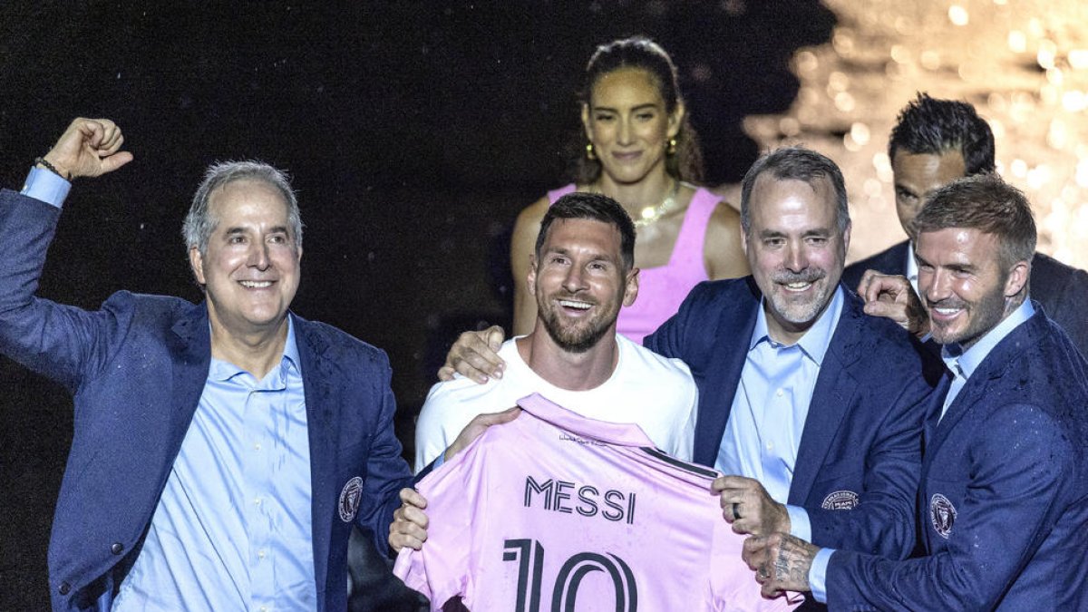 Leo Messi posa amb la nova samarreta de l’Inter de Miami amb els dirigents del club.