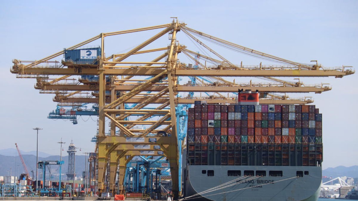 Un barco portacontenedores descargando mercancía en el puerto de Barcelona.