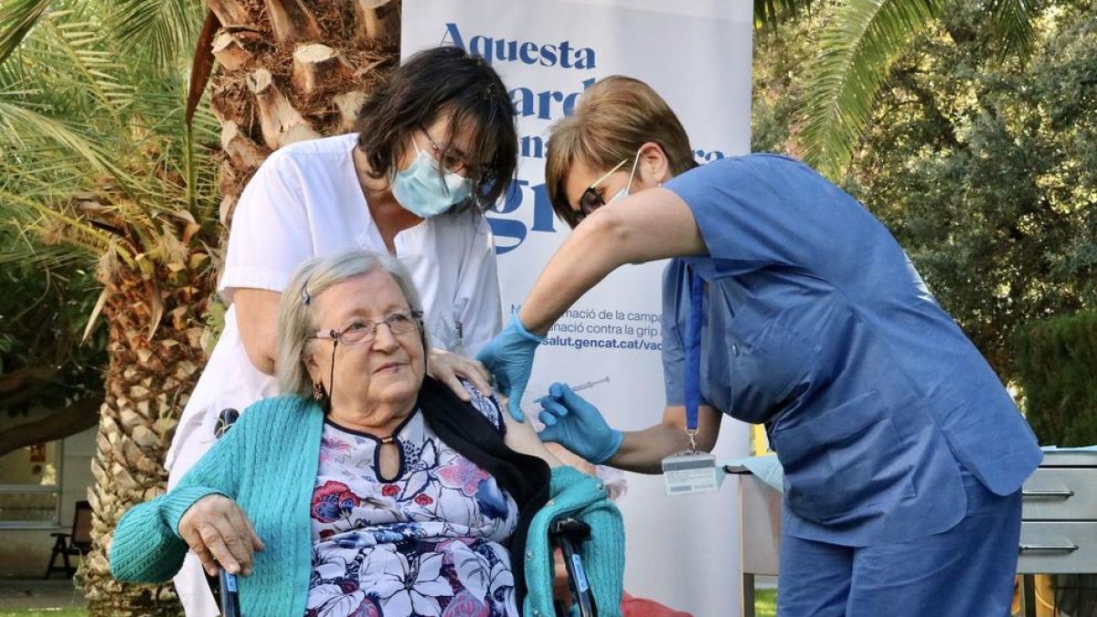 Personal sanitario administra la cuarta dosis de refuerzo de la vacuna contra la covid a Paquita Bonillo, en la residencia Feixa Llarga de L'Hospitalet de Llobregat.