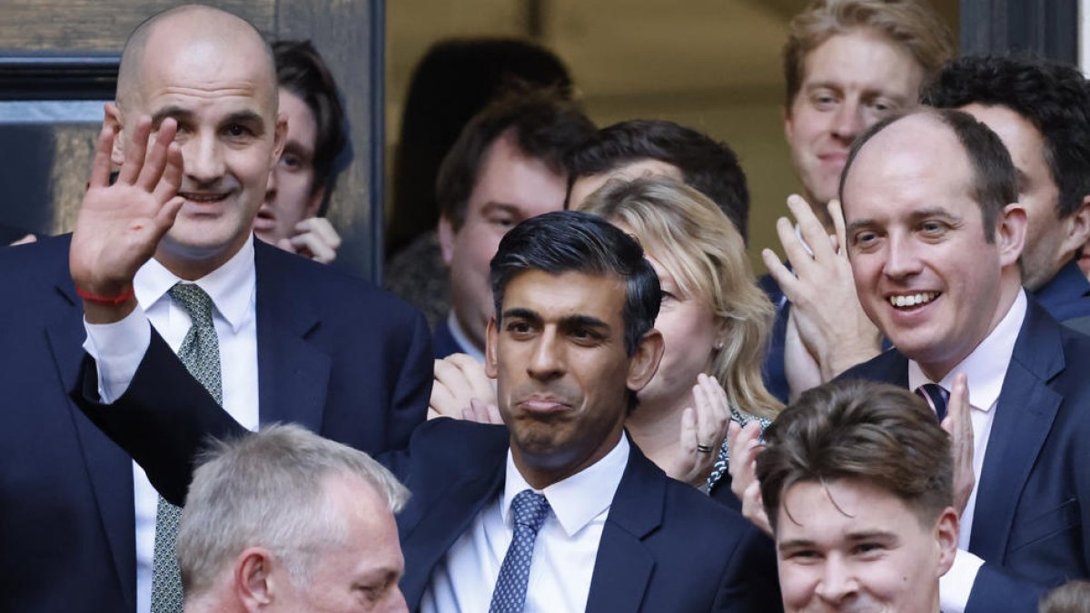 El nuevo primer ministro británico, Rishi Sunak, saluda a su llegada a la oficina del Partido Conservador.